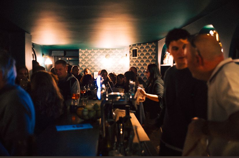L'ambiance du Badaboum un soir d'affluence, mur en écailles et lumière chaude