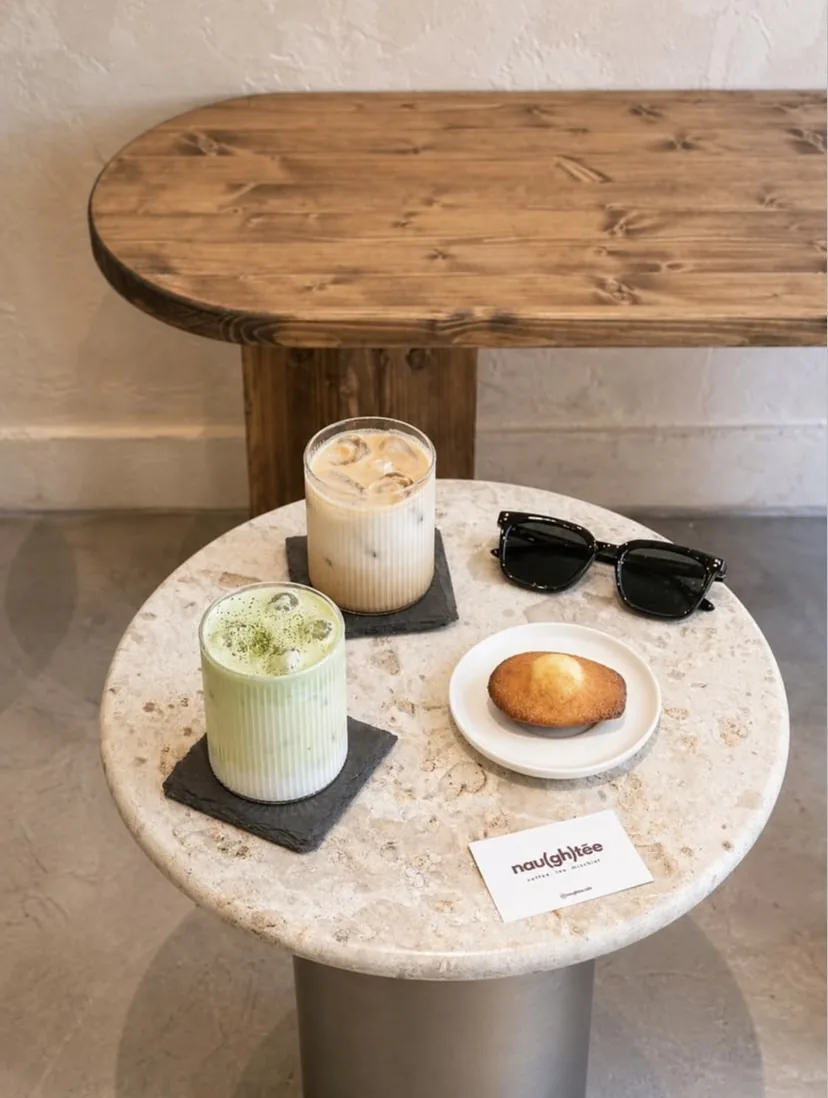 Iced matcha, iced latte et madeleine sur la table en travertin